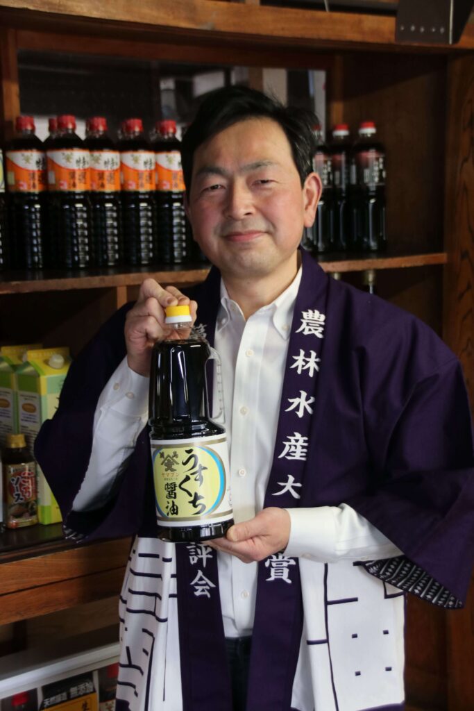 最高賞を受賞した「ヤマブンうすくち醤油」を掲げる渡辺和夫さん