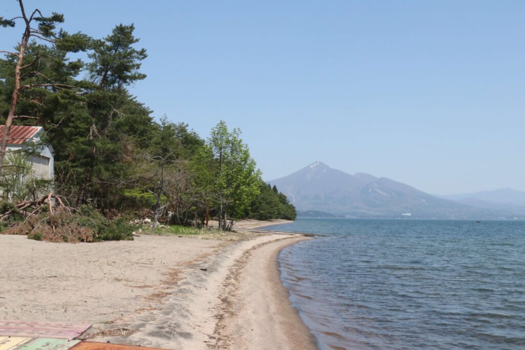 【明確になった「ライン」】上野氏と寺木氏が接近するきっかけとなった猪苗代湖西岸。プライベートビーチは林の向こうにある。