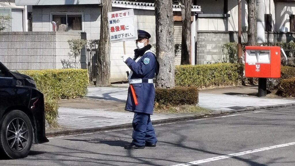 満車の看板を掲げる警備員