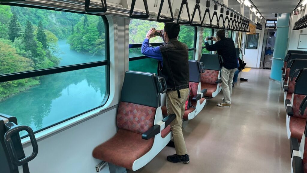 只見線の車内から外の風景を撮影する乗客(2023年5月)