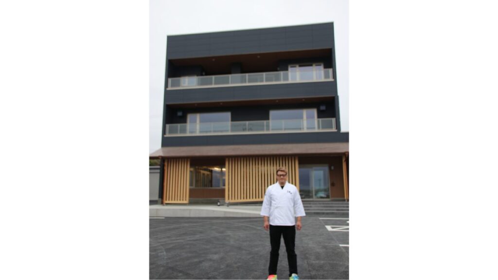 建設中の齋春商店と齋藤専務（４月28日撮影）