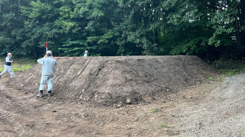 牧場に運ばれた泥混じりのチップを検測する県職員（小川社長提供）